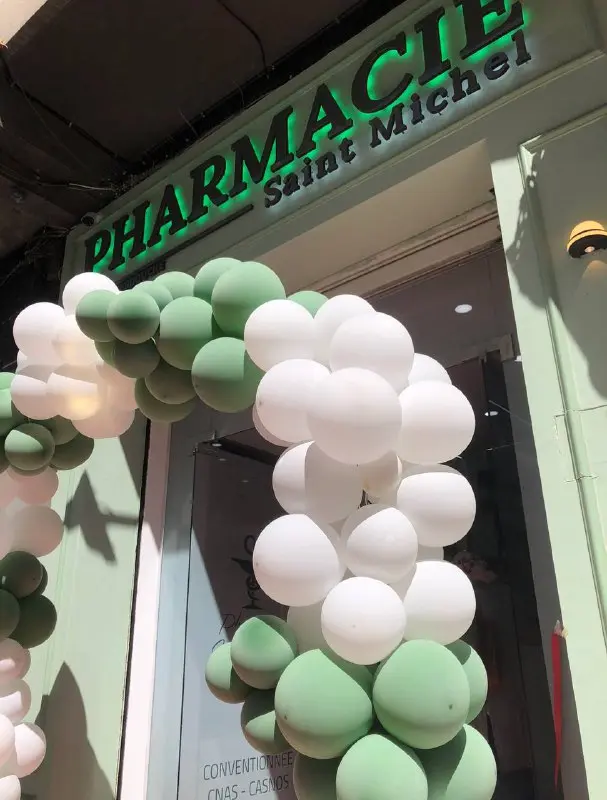 La devanture de la Pharmacie Saint Michel, enseigne verte lumineuse au-dessus de l'entrée.